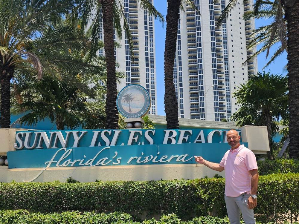Shalom Dgani, Dgani Group real estate agent, at the Sunny Isles Beach sign in South Florida