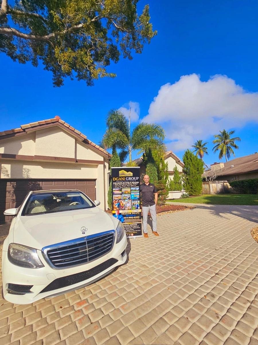 Shalom Dgani of Dgani Group with a Dgani Group sign at a South Florida home listing
