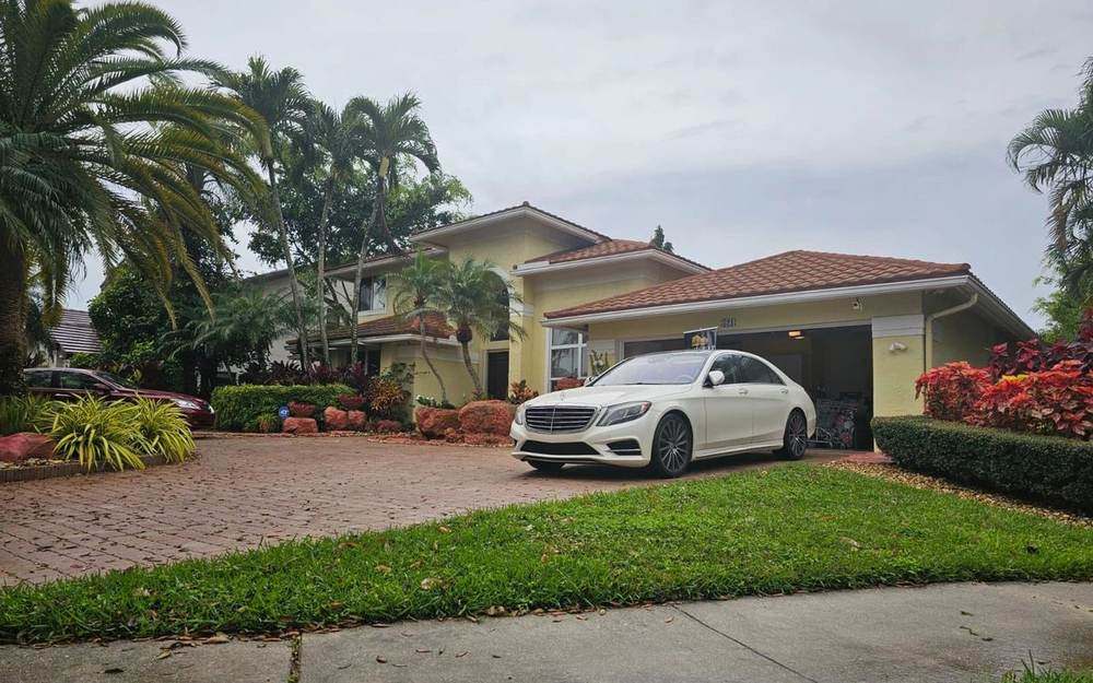 Two-story Mediterranean-style home with a paver driveway, represented by Dgani Group in South Florida