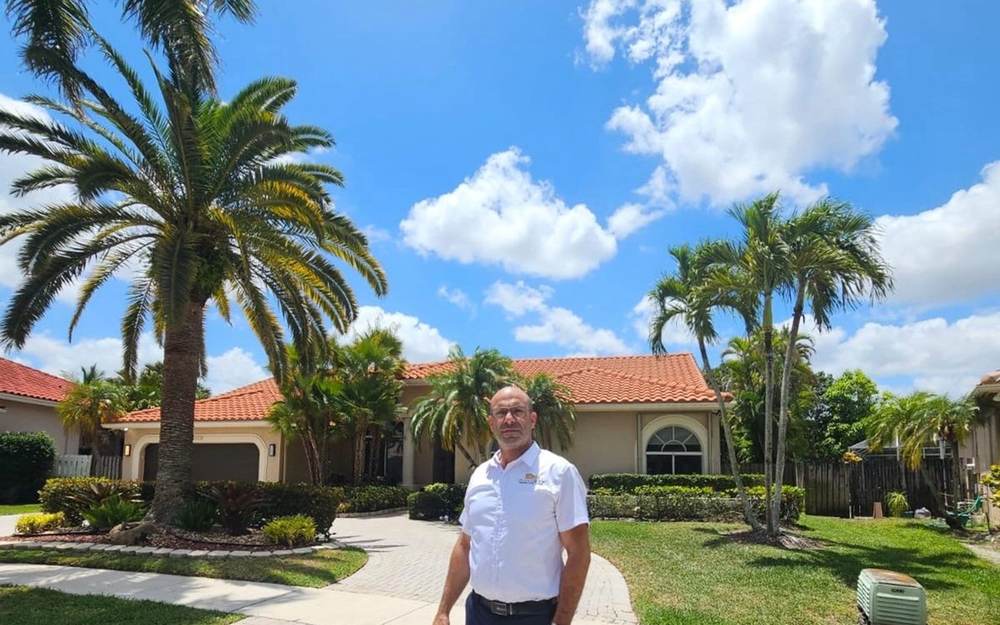 Single-story home with a tile roof and palm trees, represented by Dgani Group in South Florida