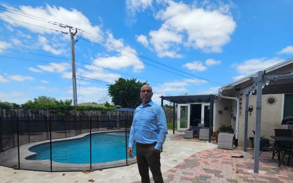 Backyard pool with a pergola patio, represented by Dgani Group in South Florida